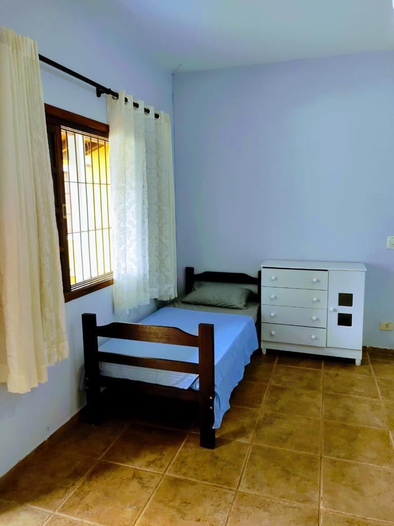 Quarto individual com cômoda e janela para o jardim